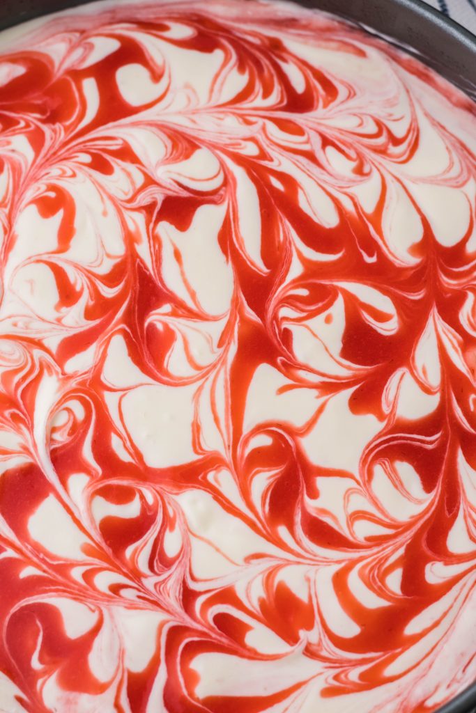 Strawberry Swirl Cheesecake| Smooth and creamy cheesecake with a homemade strawberry swirl. I don't know how it can get any better than that?!| https://bakingupmemories.com/2020/12/strawberry-swirl-cheesecake/