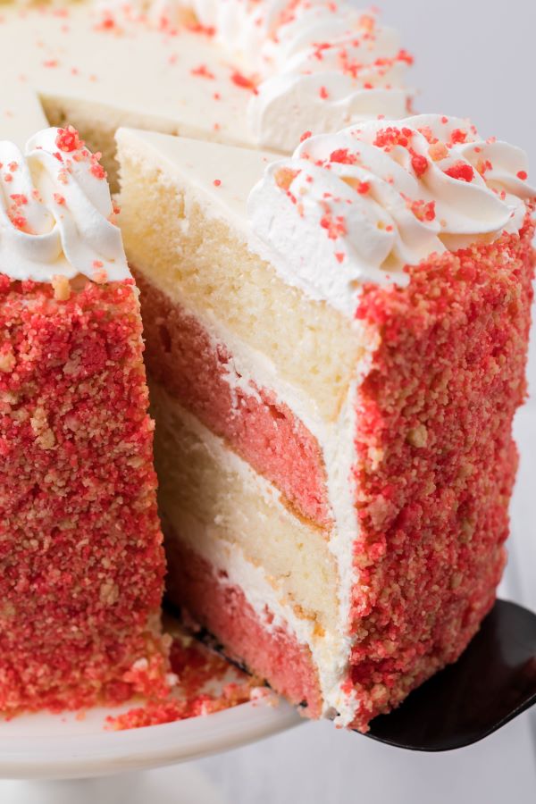 Side shot of a slice being removed from the strawberry crunch cake