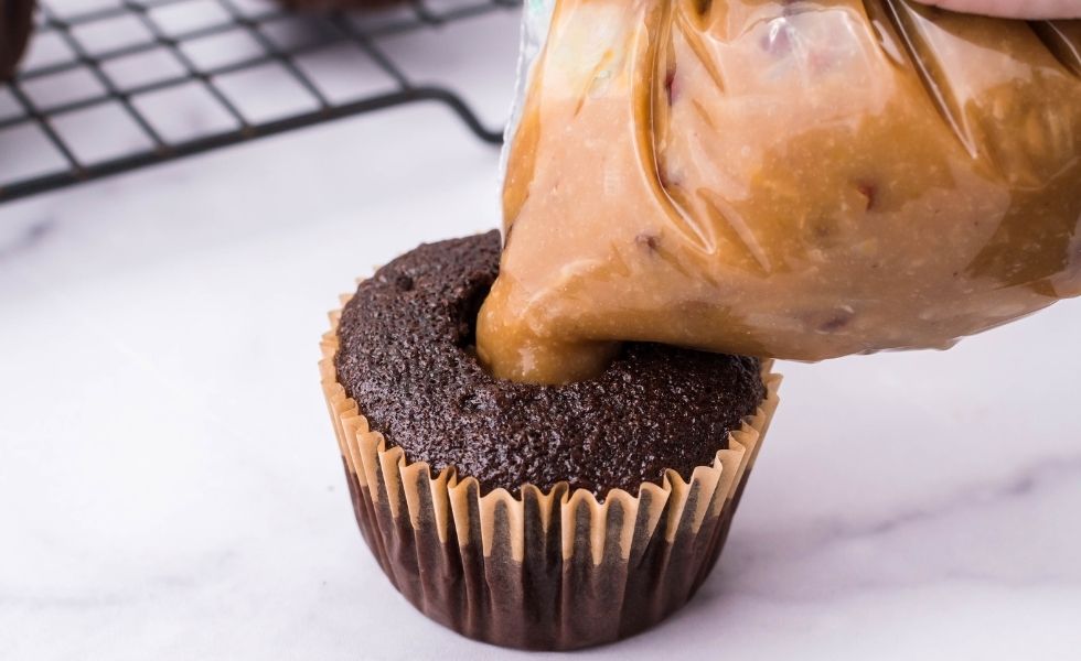 Adding filling to the center of a chocolate cupcake