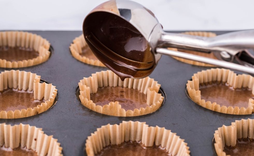 Cupcake batter being poured into liners