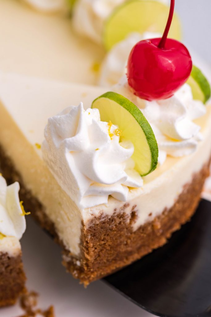 A slice of cheesecake being removed with a black spatula.