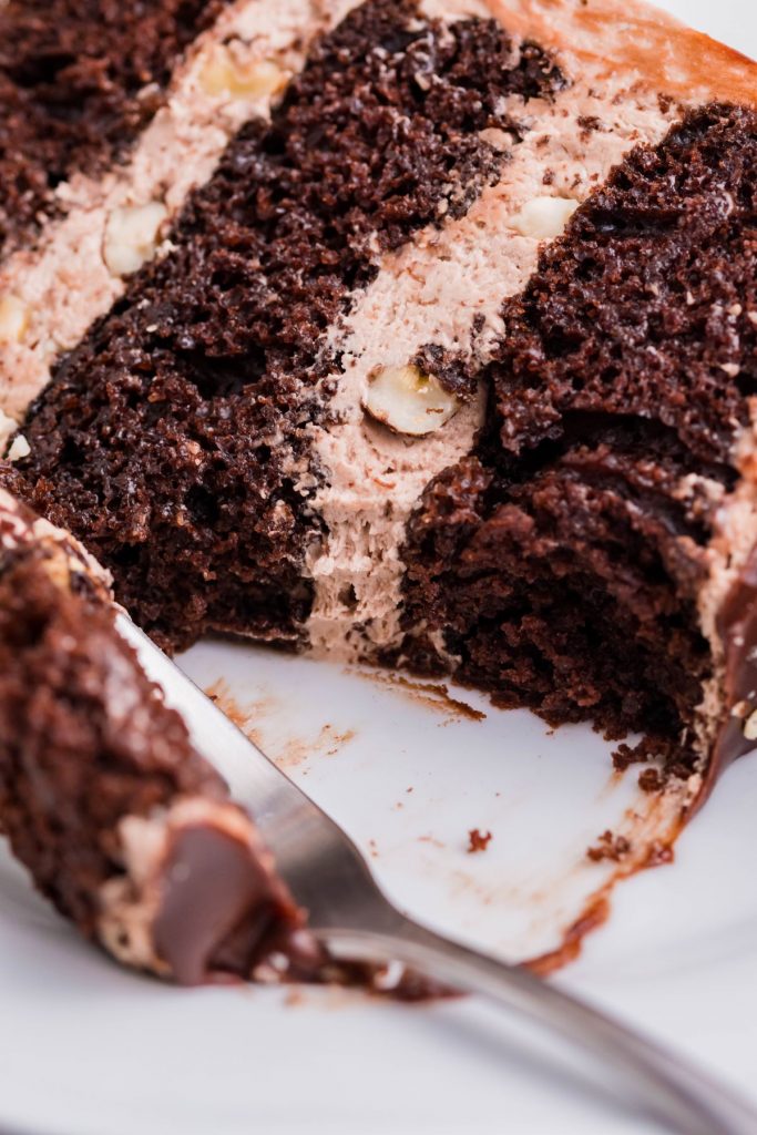 An up close view of a slice of Ferrero Rocher Cake with a bite removed. 