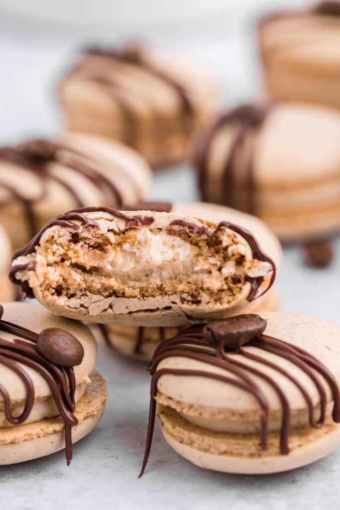 A stack of three macarons with a bite removed from the top macaron showing the Kahlua coffee filling. 