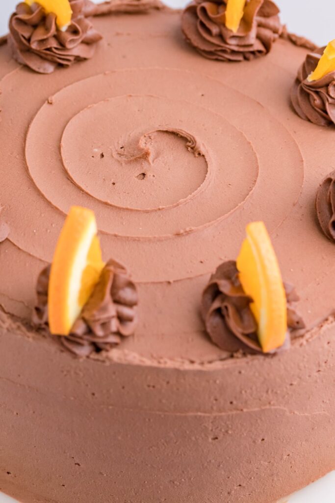 The top of the chocolate orange cake showing swirled chocolate buttercream and orange slices. 