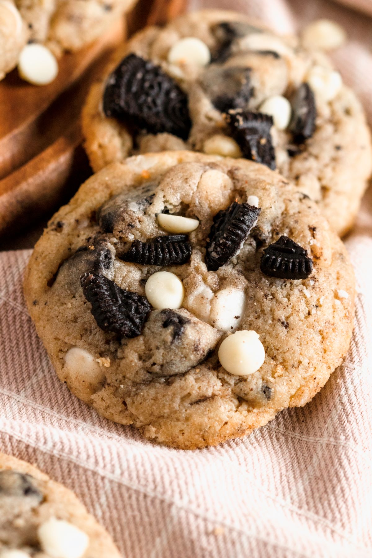 Up close view of the Oreo pieces and white chocolate chips on top of each cookie. 