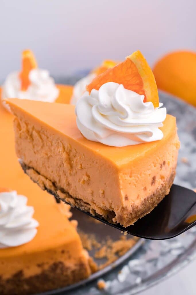 A piece of cheesecake being removed using a black spatula.