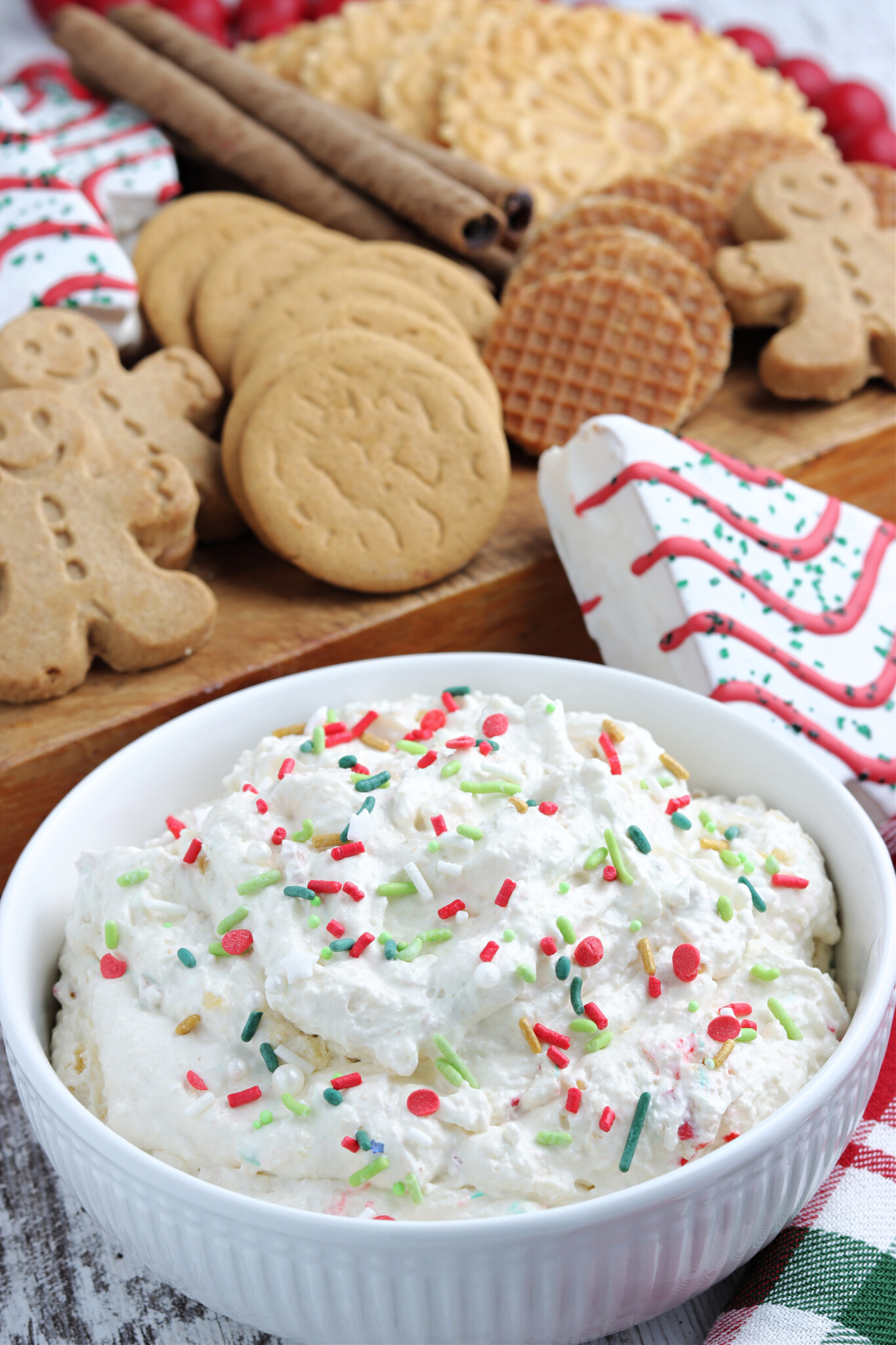 Little Debbie Christmas Tree Cake Dip in a white bowl topped with holiday sprinkles. 