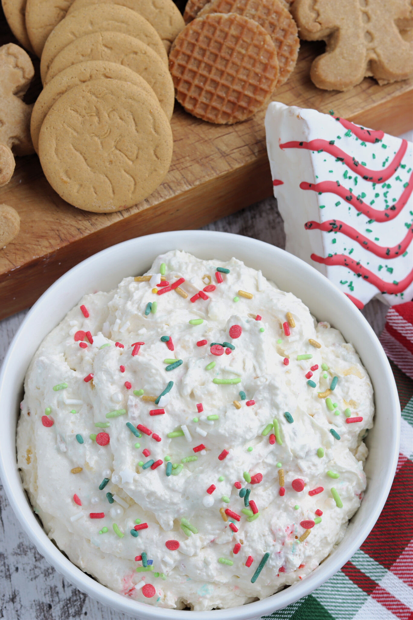 Overhead shot of Little Debbie Christmas Tree Cake Dip in a white bowl topped with holiday sprinkles. 