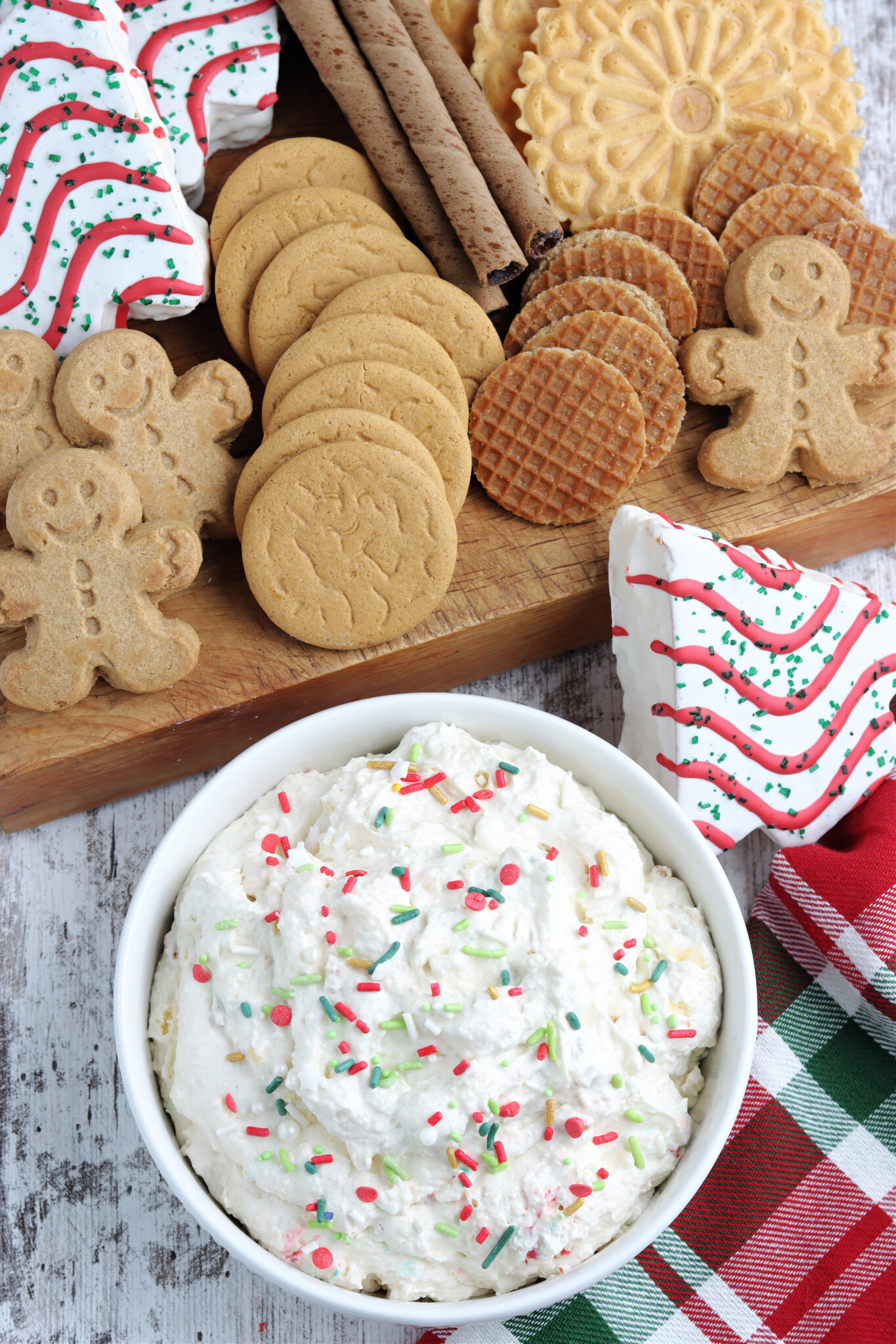 Overhead shot of Little Debbie Christmas Tree Cake Dip in a white bowl topped with holiday sprinkles. 