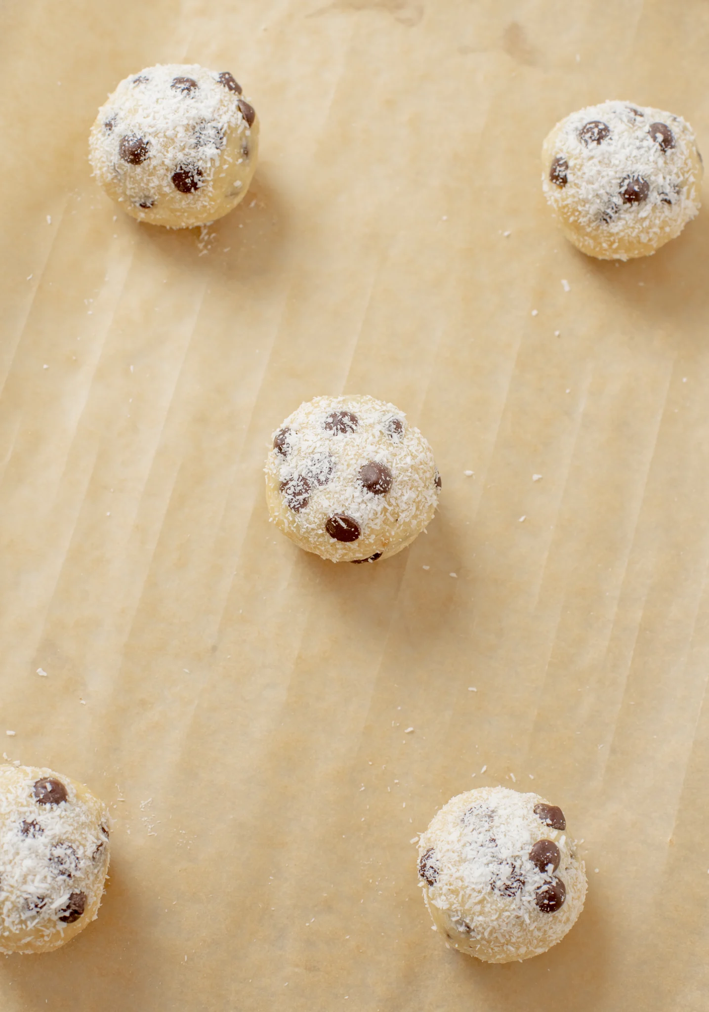 Overhead shot of the balls of dough rolled out and placed on a baking sheet. 
