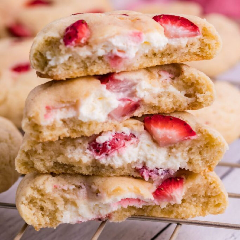 strawberry cheesecake cookies stacked and cut open to show inside filling 