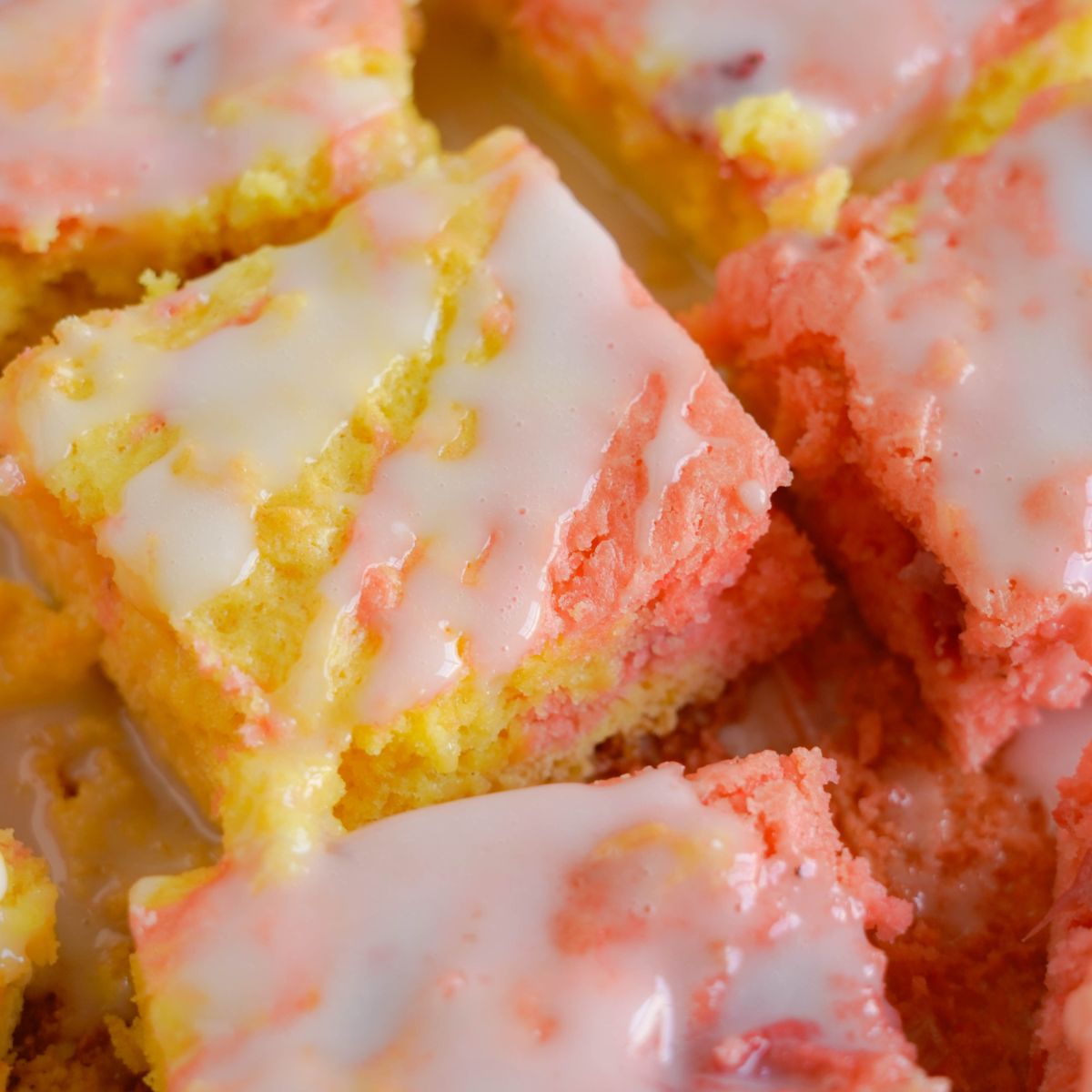 strawberry lemon blondie bars on the table with glaze on top
