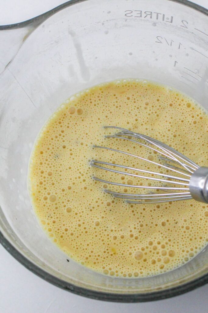 scrambled eggs in a bowl with a whisk