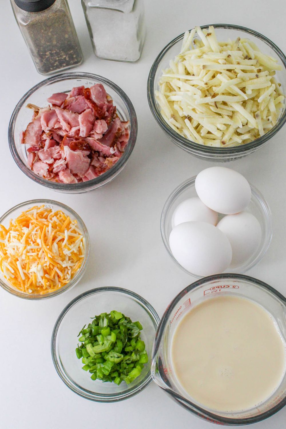 ingredients for breakfast casserole each in a small glass bowl on table 