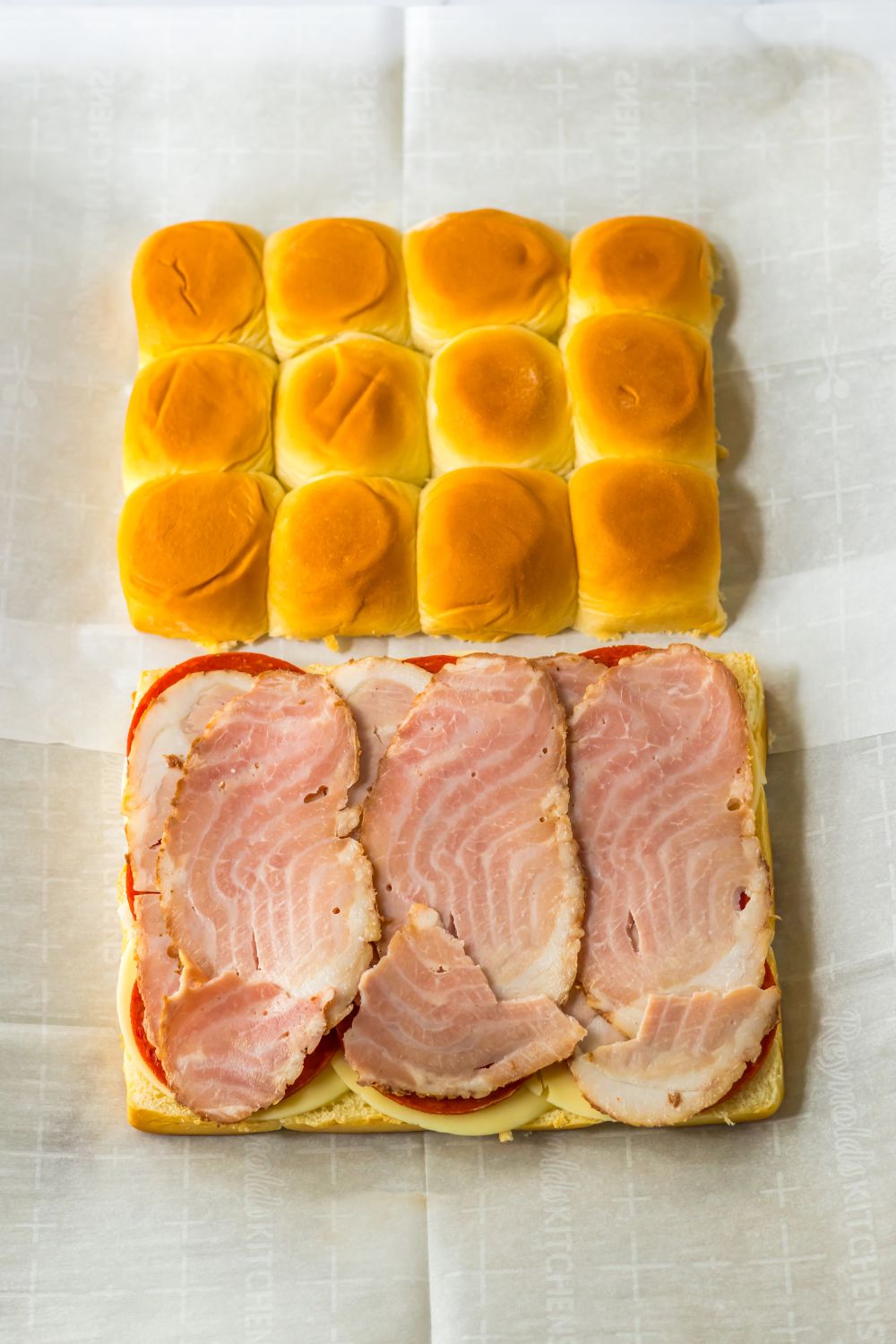 ham sliced on top of slider buns on table 