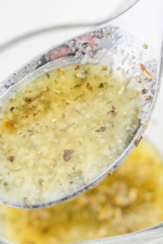 melted garlic butter in a dish with a spoon lifting out 