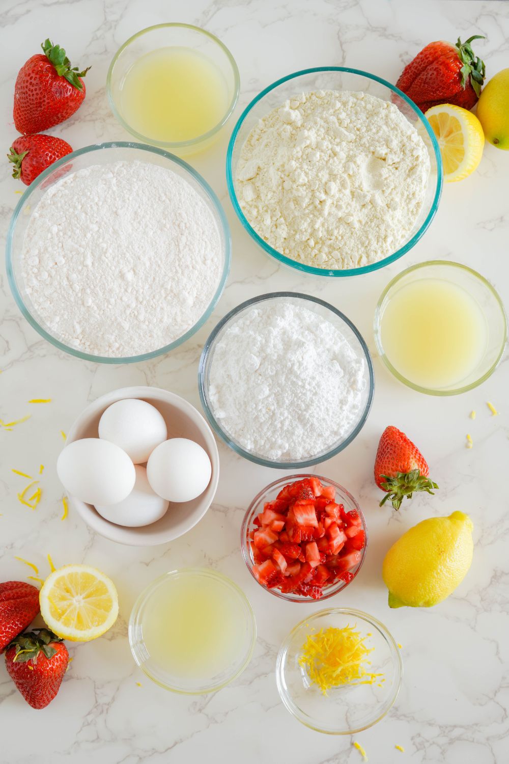 ingredients for making strawberry lemon brownies on table in glass bowls 